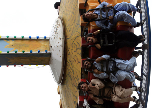 Pakistanis take a fairground ride during the Eid al-Fitr holiday in Rawalpindi on July 29, 2014. (Fa