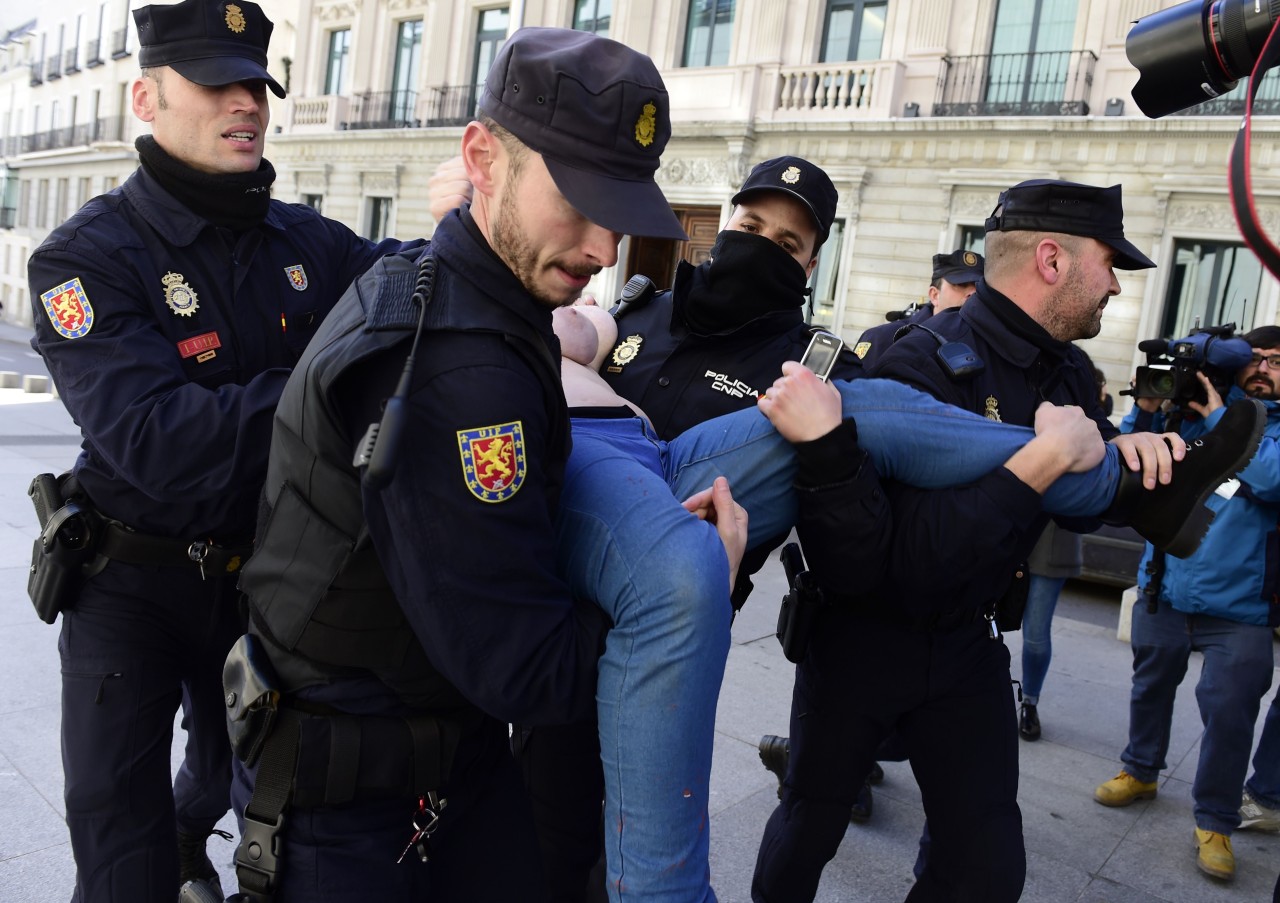 ESPAÑA. Dos activistas de Femen protestan frente al Congreso contra la ‘ley mordaza’al grito de “Protestar no es ilegal” y con los lemas “Femen for freedom” y “España sin mordaza” escritos en el torso y en la espalda desnudos. (AFP)