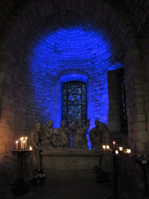 A sculptural group depicting the burial of Jesus is displayed in a dramatically lit corner of the Ba