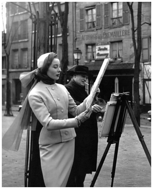 Bettina viewing artwork in suit by Givenchy. Photo by Georges Dambier, ELLE, March 2, 1953.After Jac
