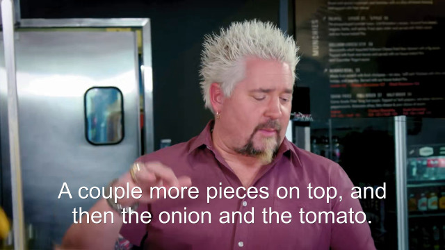 83% sure it's Guy Fieri looking at the camera. Caption: A couple more pieces on top, and then the onion and the tomato.