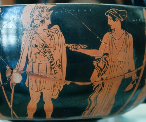 As Achilles prepares to depart for Troy, the Nereid Cymothoe holds out a phiale (shallow libation bo