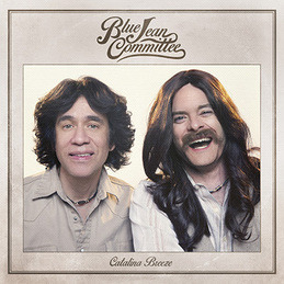 The Blue Jean Committee's Catalina Breeze album cover featuring Fred Armisen on the left as Gene Allen with chin length feathered hair and a beige shirt. Bill Hader is on the right as Clark Honus with long hair and a mustache, mid-laugh.