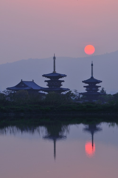 Serene sunset at Yakushi ji in Nara, by@v0_0v______mkThe sun set behind the pagodas at given time of