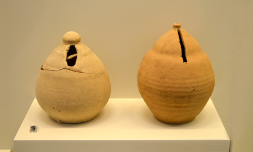 Archaeological Museum of Patra:Two clay “piggy banks”. One of them has been tampered with (left), as