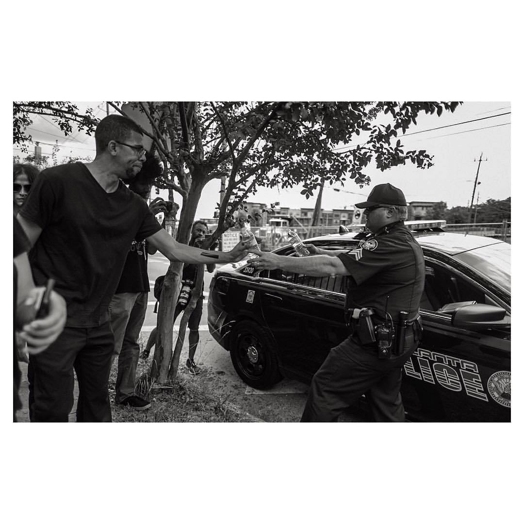 film-god:  Officer hands protesters bottled water on a hot summer afternoon ✌🏿️