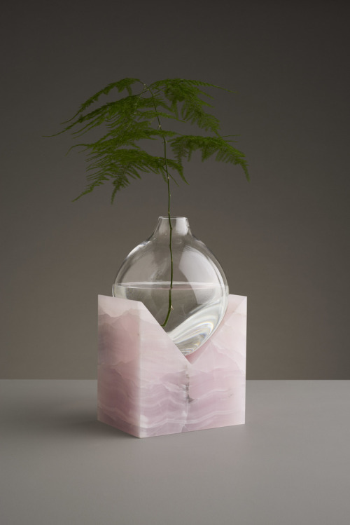 THESE SCULPTURAL GLASS VASES APPEAR TO MELT ON ANGULAR STONE FORMS 