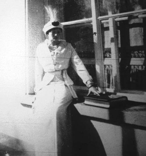 kootyl:Grand Duchess Tatiana Nikolaevna Romanov sitting on a window ledge, touching a book; looking 