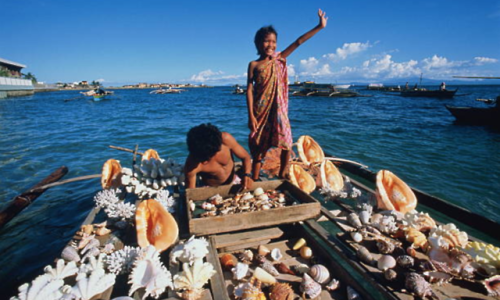 philippinespics:Cebu, Philippines, girl and boy selling shells from boatPaul Chesley