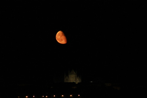 Very low, big orange moon over Orvieto cathedral