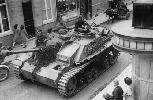 enrique262:  Damaged StuG III on the move, with one road wheel missing, another partially destroyed, and with a good chunk of the left mudguard gone.