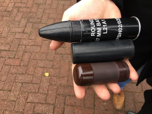 A photo showing three large rubber bullets lying in a human hand. The smallest spans the length of four fingers, the largest spans from thumb to pinky across the palm.