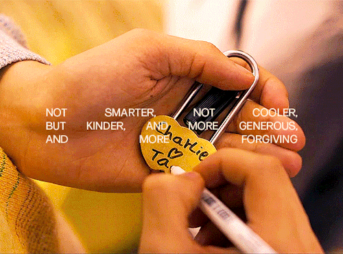 Charlie is writing "Charlie heart Tao" on the lock in his hand. In the next shot, Tao is hugging him closely while smiling. The text in the gif says: "not smarter, not cooler, but kinder, and more generous, and more forgiving"