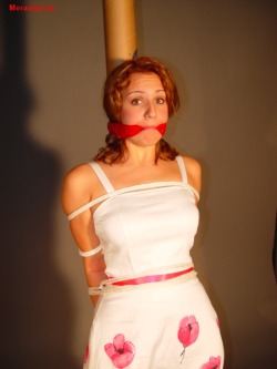 graybandanna:  Girl in a cute dress tied to a pole with a red bandanna gag 