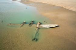 museum-of-artifacts:   Sixty-five years after it crash-landed on a beach in Wales, an American P-38 fighter plane has emerged from the surf and sand where it lay buried   