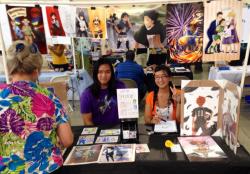 chuudaime:  Here’s a picture of my and Jon’s table at ACE14!!! Taken off of the ACE facebook page~  =D I&rsquo;m a pro animu person