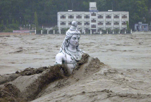 skinnyknees:A submerged statue of the Hindu Lord Shiva amid the flood waters of the river Ganges, Ju