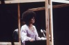 rumman:Angela Davis speaking behind a four-sided bulletproof glass shield at Madison Square Garden, 29 June 1972.