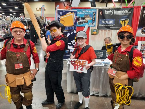 Part of our group standing in front of an author's booth. Sniper, Scout, and two Engineers.