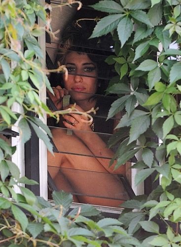 Amy Winehouse Passing Ice Pops To The Neighborhood Kids Outside The Window Of Her North London Home (2008)