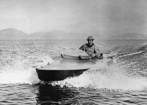 Giacomo Puccini driving a motorboat.