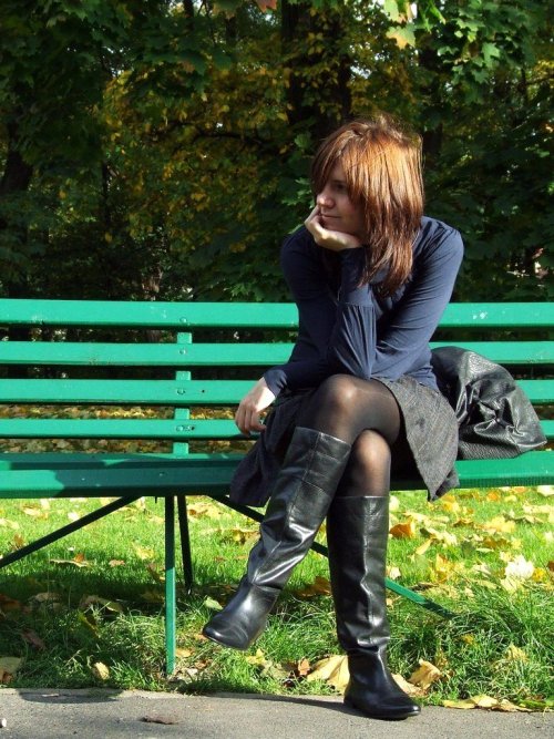 Working lady in black pantyhose and boots caught on a bench.Woman in pantyhose