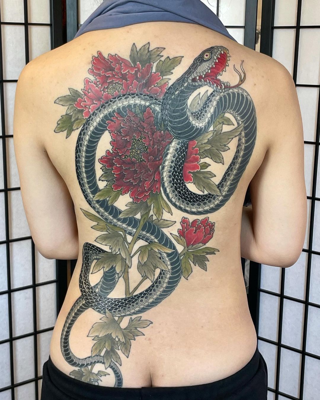 Fine line snake tattoo on the back