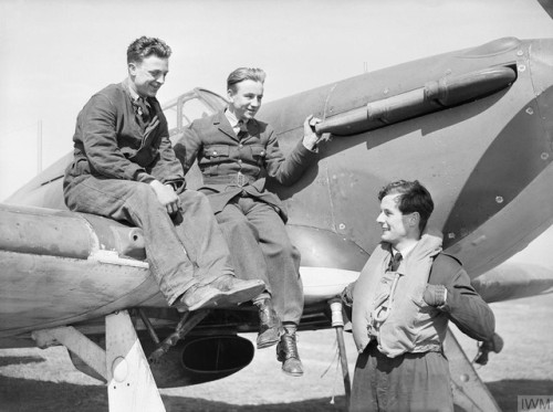 Squadron Leader Peter Townsend DSO DFC chats with his ground crew,who are sitting on his Hawker Hurr