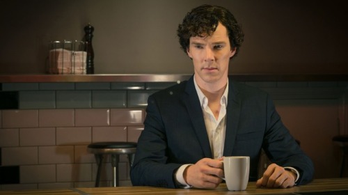 Benedict touching a mug handle with excessive thought.