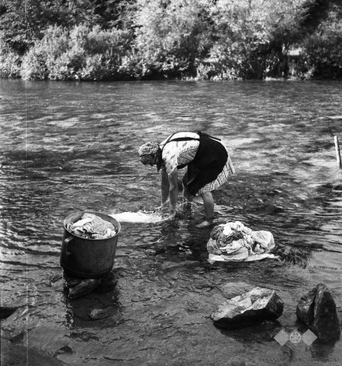 Woman washing clothes in the river, Slovenia