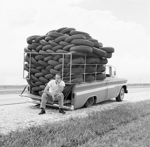 luzfosca: A man experiences irony as his car, laden with used tires, has a flat tire, Houston, Texas