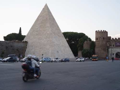 Scooter passing the Pyramid of Cestius in Rome.