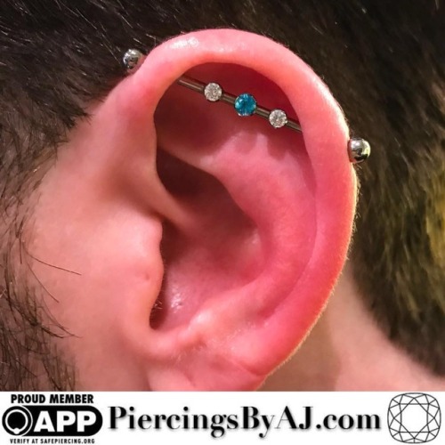 12ozstudios: Fully healed industrial with a 3 gem barbell featuring a genuine paraiba topaz centerpi