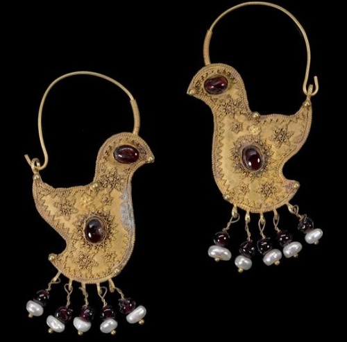 A pair of gold hoop earrings in the form of birds, with hook and eye clasp, each with garnet set to 