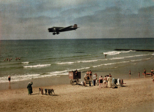 People on the beach in Germany as a plane flies overhead, 1928.Photograph by Wilhelm Tobien, Nationa