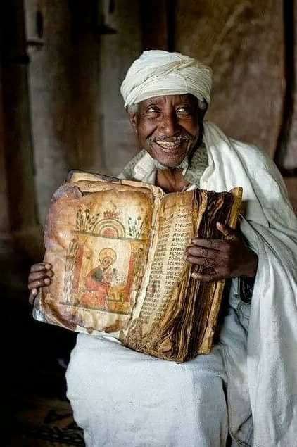 The 800 year old Bible in the hands of an Ethiopian priest.The Bible is written on the goatskin.