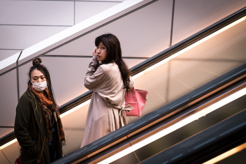 Two ladies going up an escalator in Shinjuku, Tokyo.Photo : Pierre-Emmanuel Delétrée