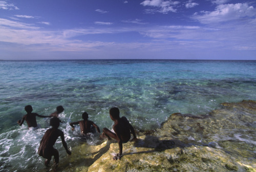 unrar: Kids swimming along the rocky coast of Great Exuma Island. Michael Melford.