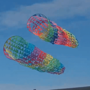 two rainbow mesh spinner kites being flown