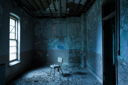 ianference:This photo, taken towards the end of nautical twilight/beginning of civil twilight, depicts a lone chair in a patient room in the Maples Building at Willard State Hospital.  Above the chair, the last orange strains from the sodium vapor lamps