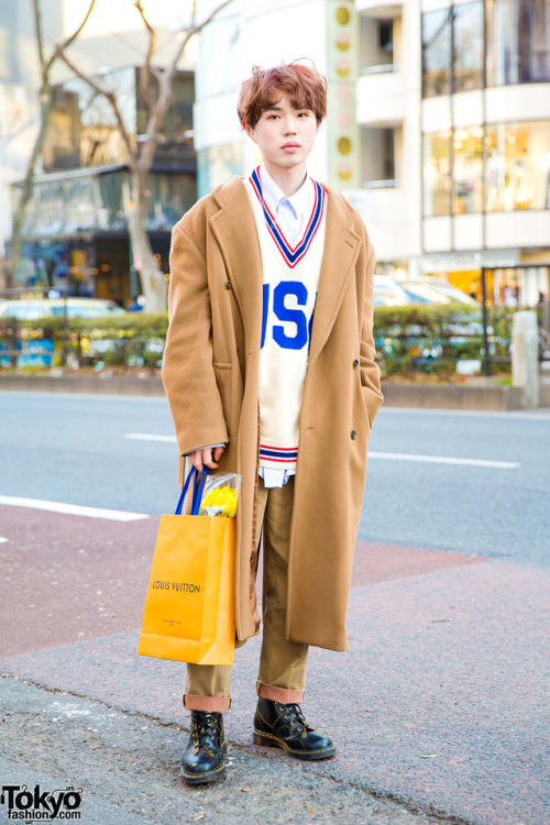 18-year-old Sohtaroh on the street in Harajuku wearing a tan coat over a v-neck sweater, tan cuffed 