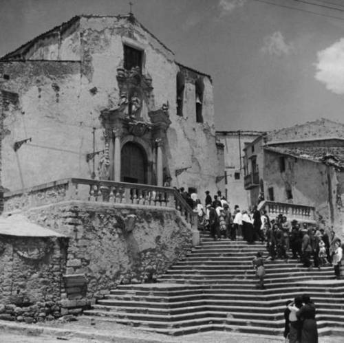Wedding guests on the steps of the church in Piana dei Greci, Sicily. Circa 1950.