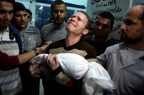 1:  Nov. 18, 2012 file photo, a Palestinian man kisses the hand of a dead relative in the morgue of 