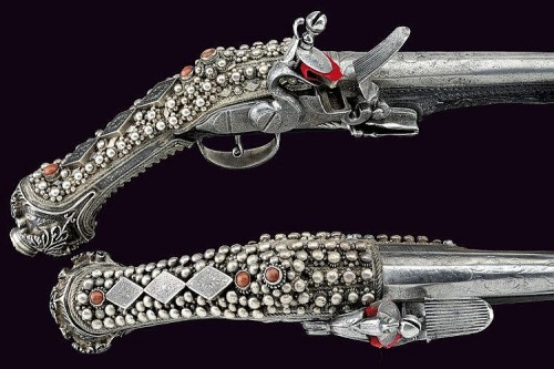 Cased pair of “Ali Pasha” style flintlock pistols mounted with silver and semi-precious 