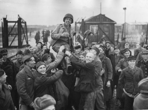 historicaltimes:Russian prisoners of war lifting up an American soldier after the US 9th Army libera