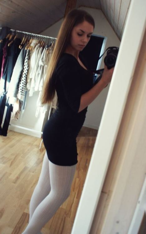 Selfshot of a sexy girl in white wool pantyhose and tight dress. Woman in pantyhose