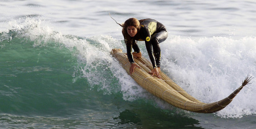 Sofia Mulanovich Peruvian surfer rides a wave on top of a “caballito de totora” so ancie