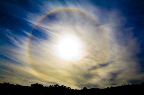 sixpenceee: The sun halo effect is an optical phenomena that’s caused by sunlight passing through ice crystals in cirrus clouds within the Earth’s atmosphere. The crystals bend direct sunlight, projecting it elsewhere into the sky. When it’s bent