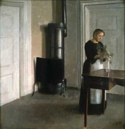 Interior with a woman placing branches in vase on table  - Vilhelm Hammershøi ,c. 1900.Danish, 1864-