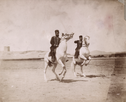 Two Turkish officers ride their horses in the sandy region